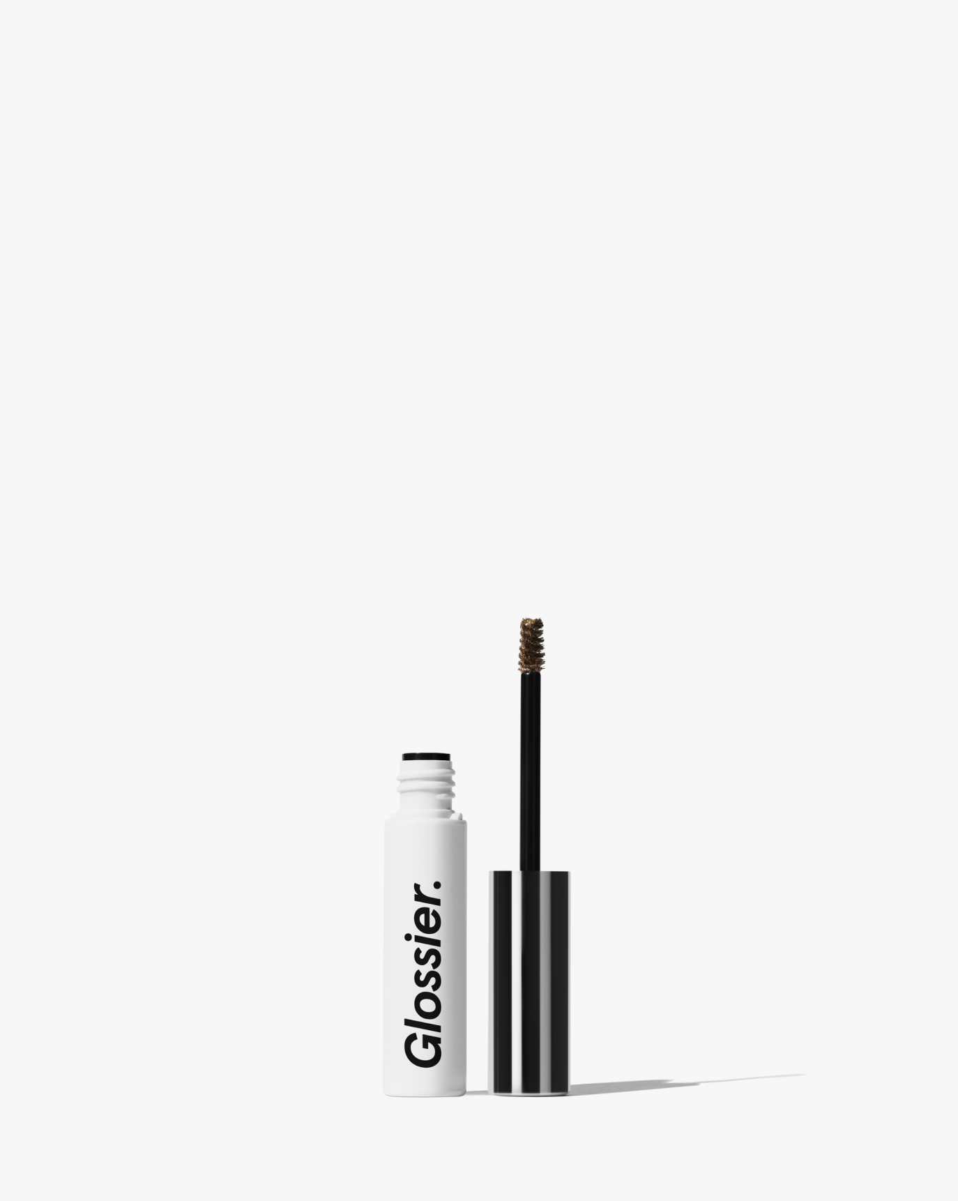 Glossier Boy Brow single product shot with white tube and black applicator wand standing on pristine white background with 70 percent negative space