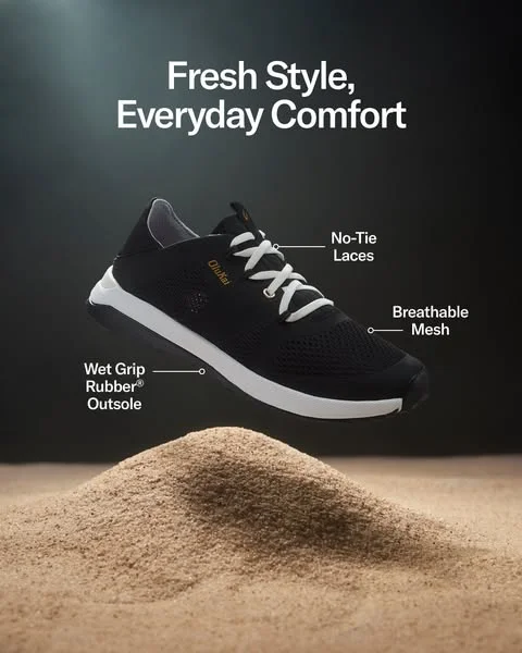 OluKai shoe suspended above a sand dune in a dramatic static ad