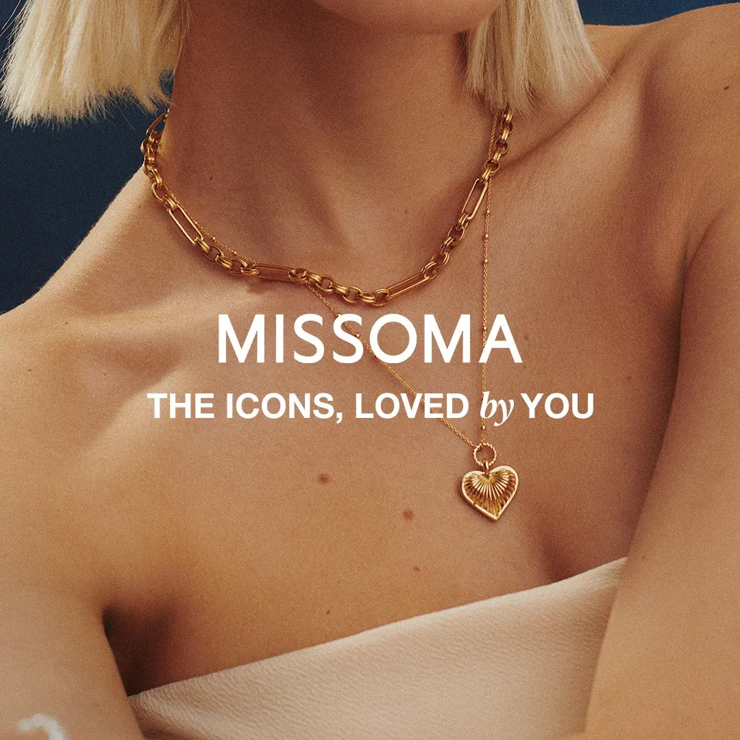 Missoma necklace ad: a woman's collarbone with a gold paperclip chain and a long chain with a ridged heart pendant, "The icons, loved by you"