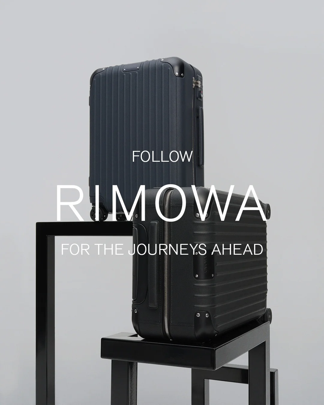 Rimowa luxury ad example: two suitcases stacked on black plinths against gray with a huge thin wordmark