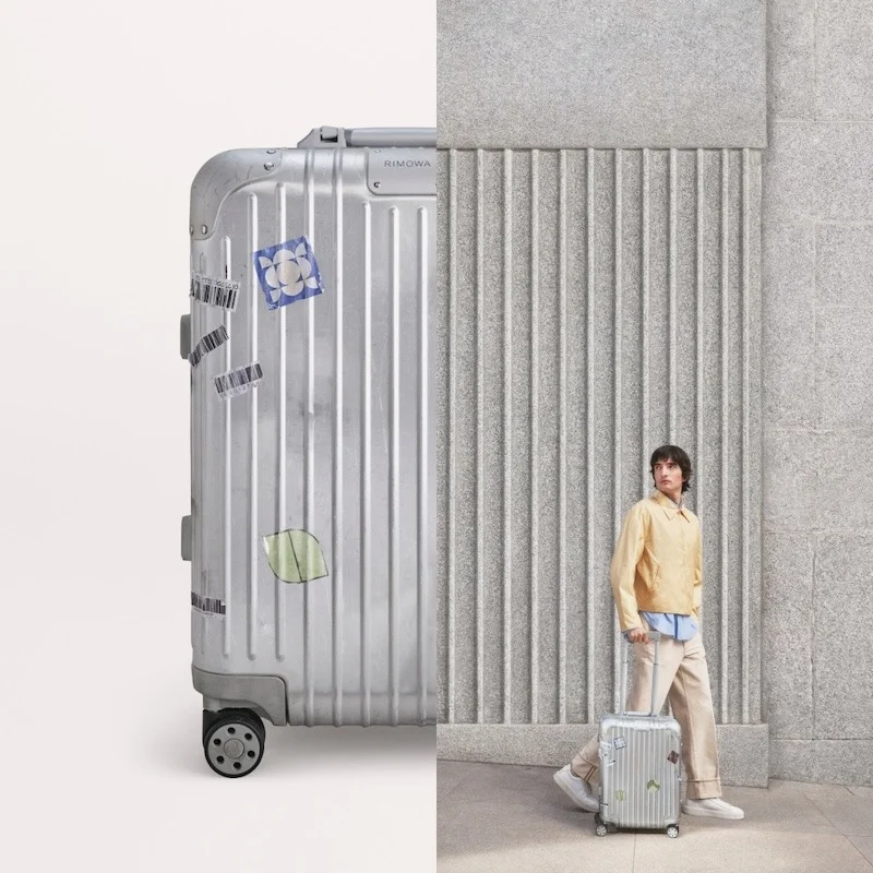 Rimowa luxury ad example: sticker-covered aluminum case macro beside a model wheeling a cabin case